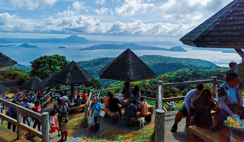 Tourists enjoy a picnic while looking at the beautiful Taal Volcano.