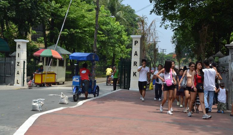 Tourists visit the Rizal Park with summer attire.