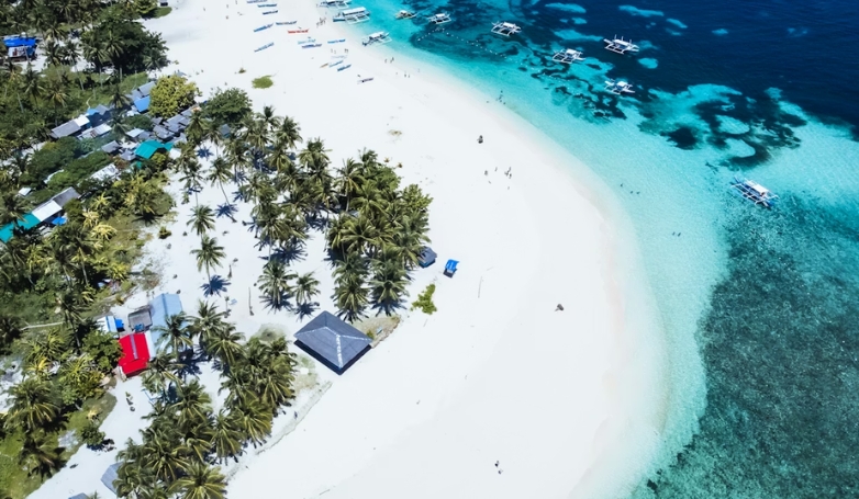 Aerial view of Union Beach in Siargao, showcasing its white sand and vibrant blue water.