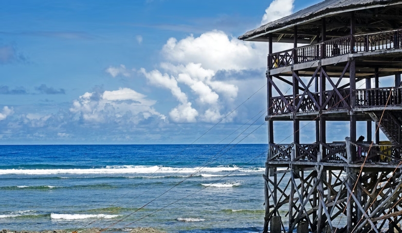 A beachside wooden structure at Union Beach, Siargao, with a vibrant blue sky above.